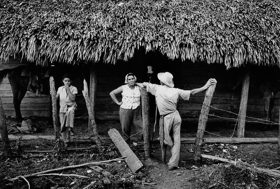 Cuba, Habitants du village de Guamo devant leurs maisons, abîmées par le passage d'un ouragan, 1963